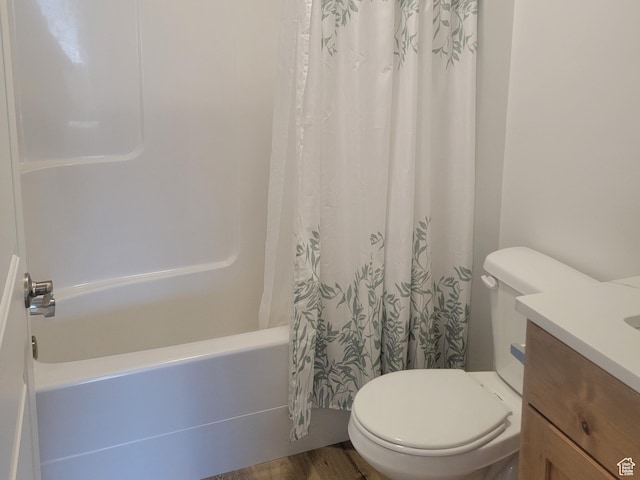 full bath featuring vanity, wood finished floors, toilet, and shower / bath combo with shower curtain