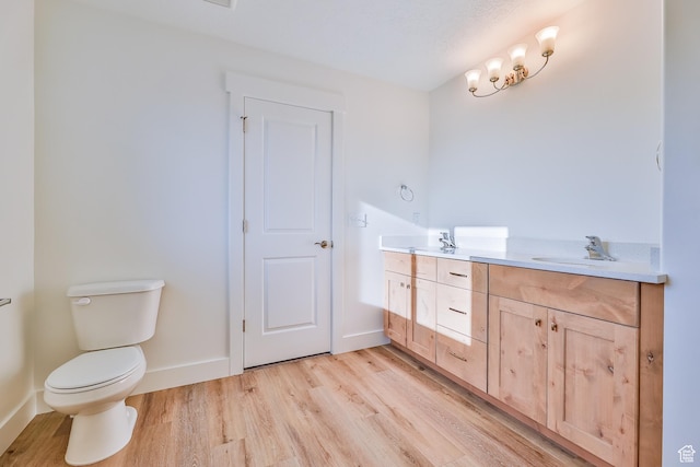full bathroom featuring double vanity, toilet, a sink, and wood finished floors