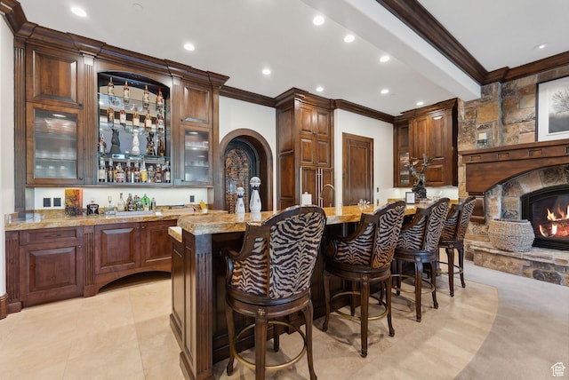 340 Hollyhock St, Park City, UT 84098 - bar featuring ornamental molding, wet bar, recessed lighting, arched walkways, and a stone fireplace