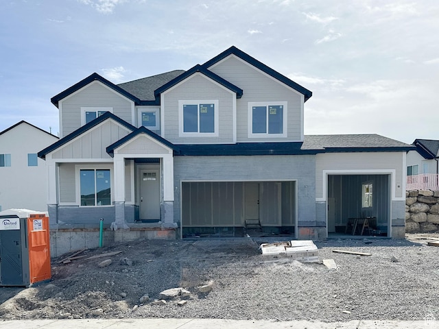 view of front of home with roof with shingles, board and batten siding, and an attached garage