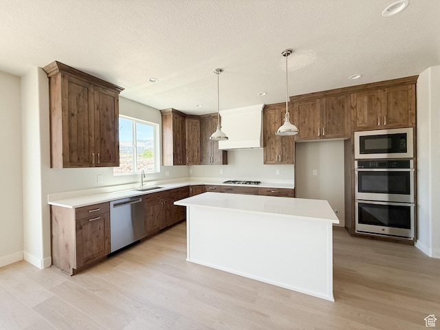 1546 S Lukas Ln, Saratoga Springs, UT 84045 - kitchen with appliances with stainless steel finishes, light wood finished floors, premium range hood, recessed lighting, and a center island