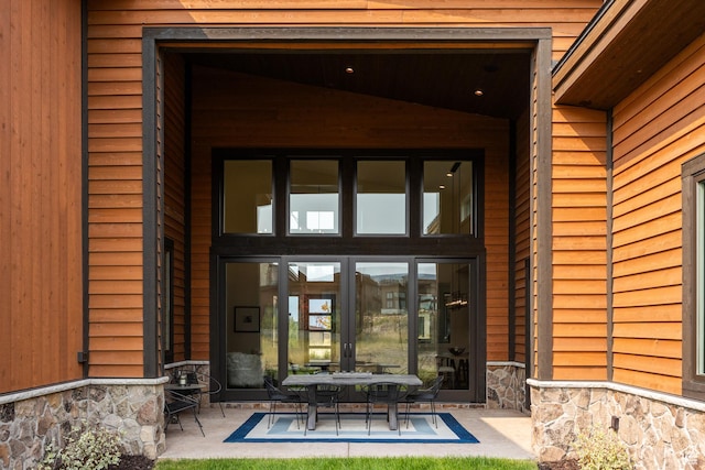 doorway to property featuring stone siding and a patio area