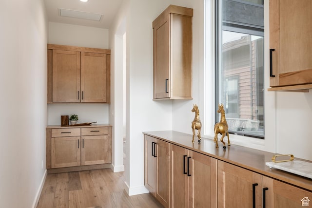 bar featuring baseboards, light wood-style floors, and visible vents