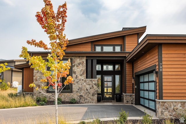 property entrance featuring stone siding and an attached garage