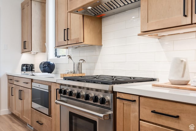 kitchen featuring custom range hood, light countertops, stainless steel appliances, and backsplash