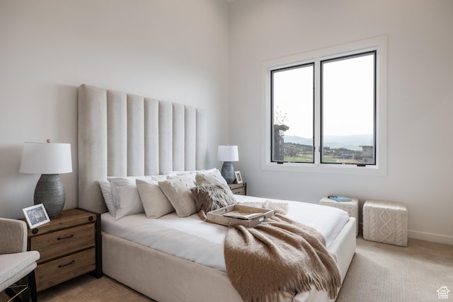 bedroom with light carpet and baseboards