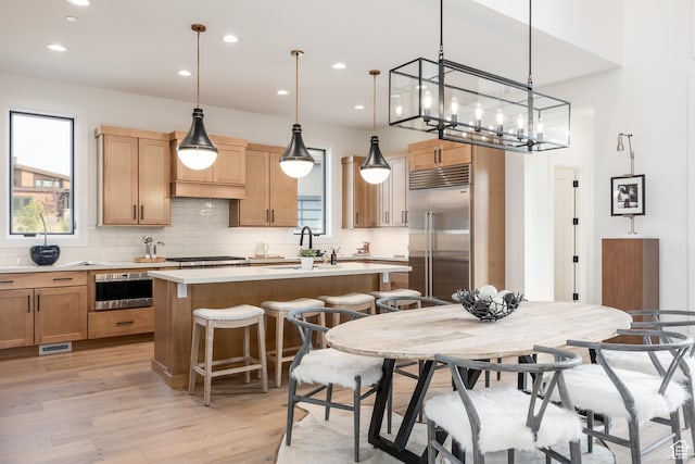 kitchen featuring a kitchen island, light countertops, appliances with stainless steel finishes, and a healthy amount of sunlight