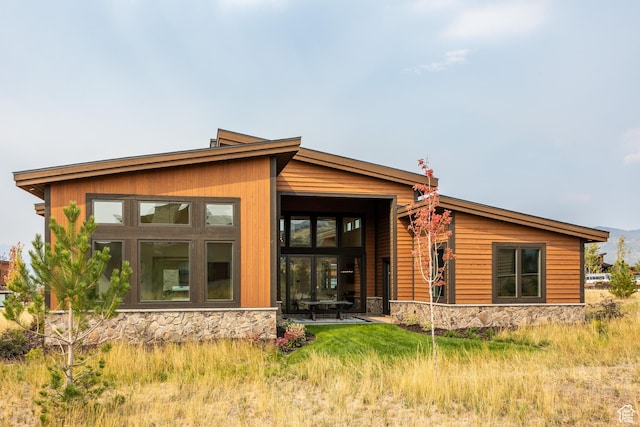 rear view of house with stone siding