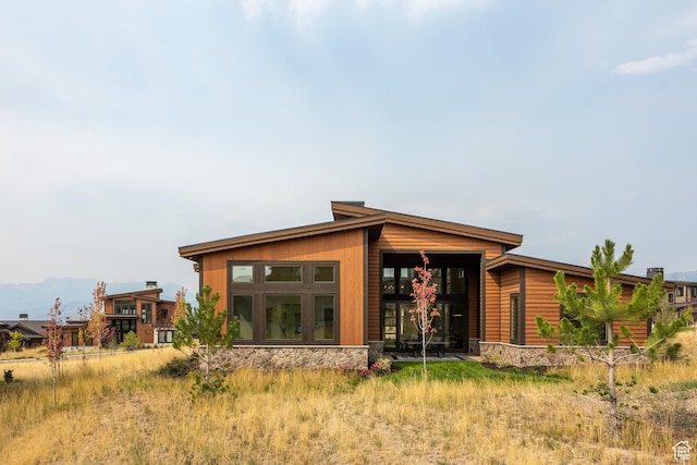 rear view of house with stone siding