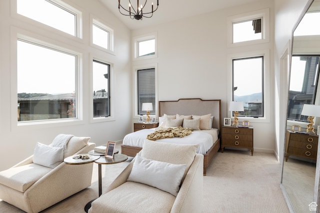bedroom featuring light colored carpet, a high ceiling, baseboards, and a chandelier