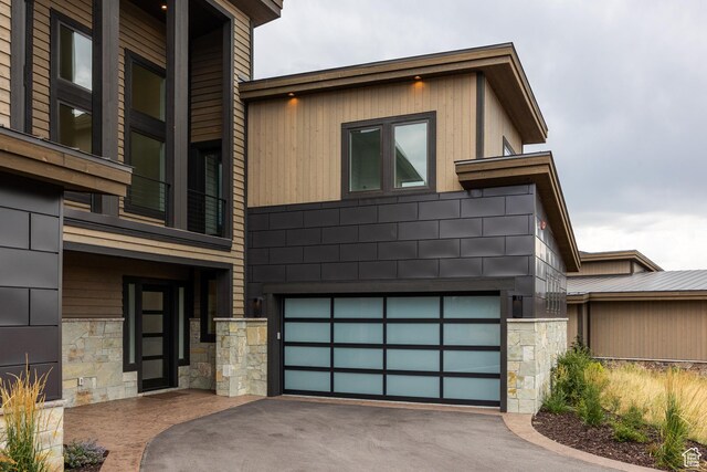 838 N Burro Peak Cir, Heber City, UT 84032 - modern home with stone siding, an attached garage, and driveway