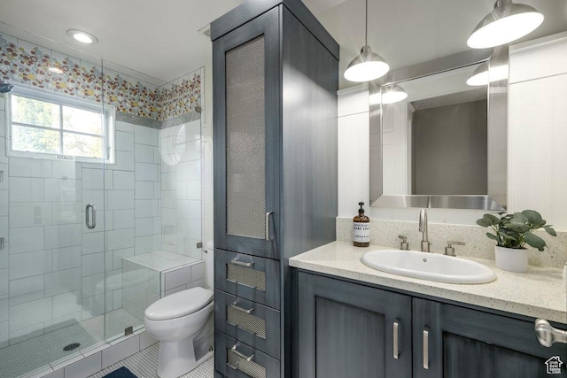 full bathroom featuring toilet, vanity, and a shower stall