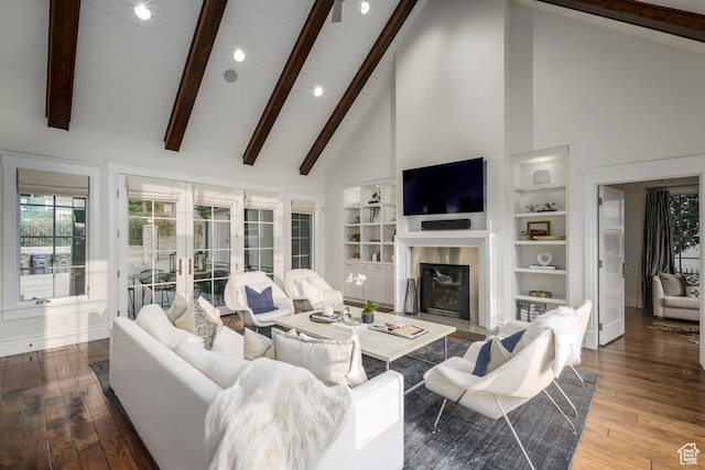 living room featuring high vaulted ceiling, beam ceiling, hardwood / wood-style flooring, french doors, and a fireplace