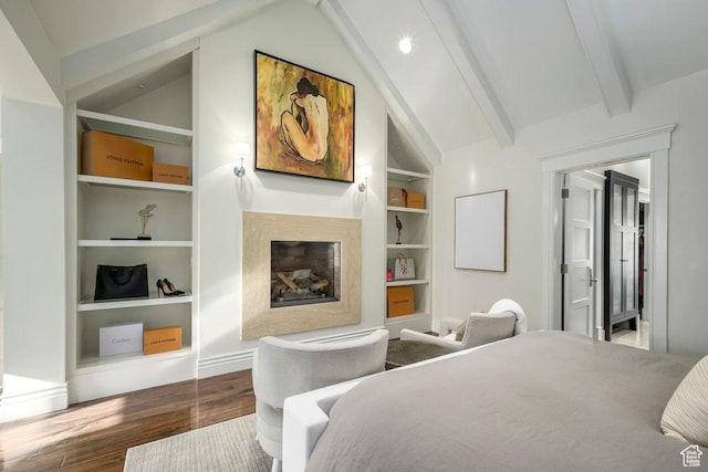 bedroom with a fireplace, vaulted ceiling with beams, and wood finished floors