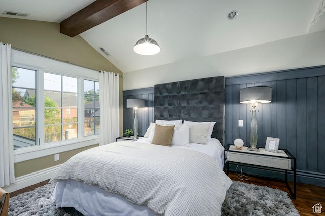 bedroom with baseboards, visible vents, vaulted ceiling with beams, and wood finished floors
