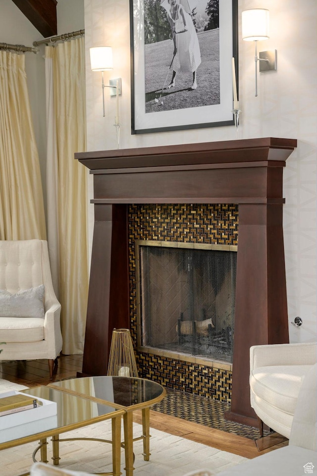 interior details with a tile fireplace and wood finished floors