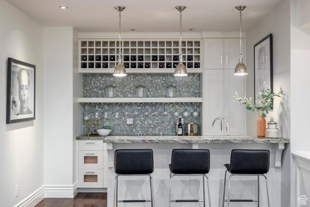 1137 S Douglas St E, Salt Lake City, UT 84105 - bar with baseboards, wet bar, a sink, dark wood-style floors, and backsplash