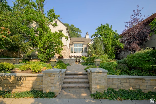 view of front facade featuring stucco siding and a chimney