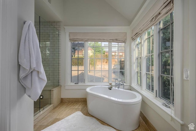 full bath with a freestanding tub, a stall shower, and vaulted ceiling