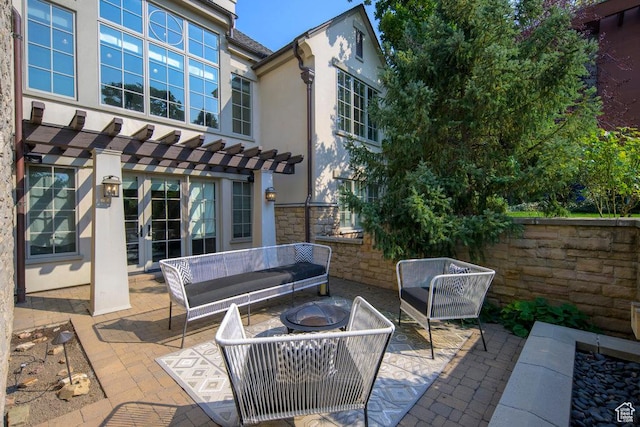 view of patio with french doors, an outdoor living space with a fire pit, a pergola, and fence