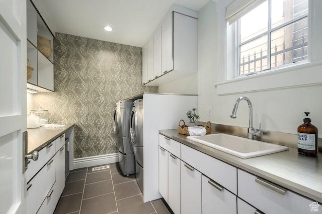 laundry area with a sink, baseboards, independent washer and dryer, wallpapered walls, and cabinet space
