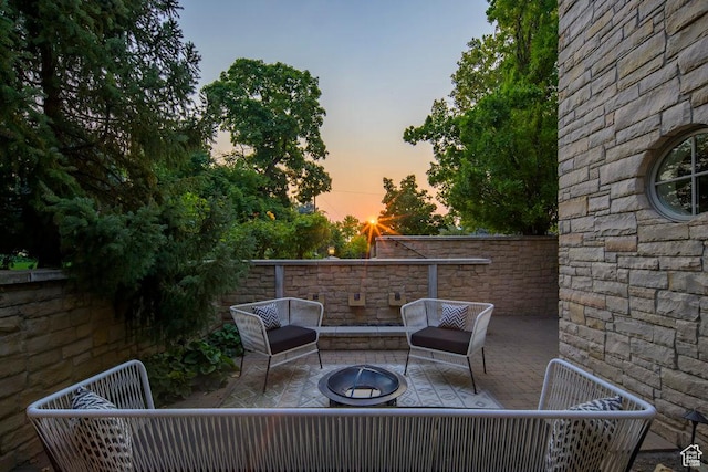 patio terrace at dusk featuring a fire pit