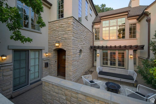 doorway to property featuring stone siding and stucco siding