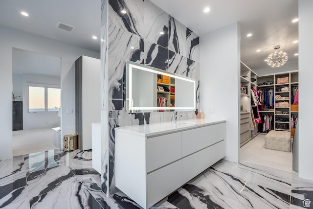 405 N Virginia St, Salt Lake City, UT 84103 - bathroom featuring marble finish floor, recessed lighting, vanity, stone wall, and a spacious closet