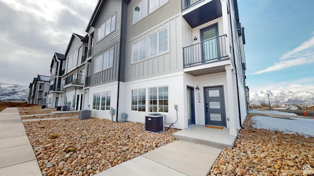 view of building exterior featuring central air condition unit and a mountain view
