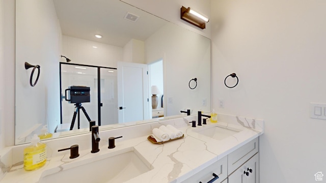 full bathroom featuring a sink, visible vents, a shower stall, and double vanity