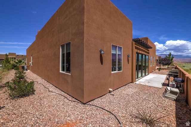 3243 S 4900 W, Hurricane, UT 84737 - view of side of home featuring stucco siding, cooling unit, and a patio area