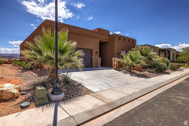3243 S 4900 W, Hurricane, UT 84737 - pueblo revival-style home featuring concrete driveway, stucco siding, and an attached garage