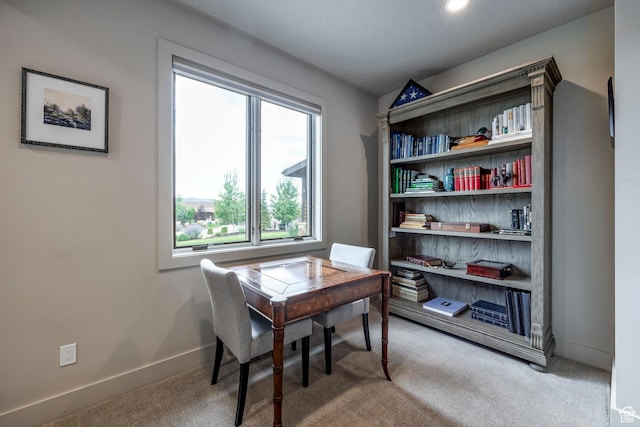 carpeted home office featuring baseboards