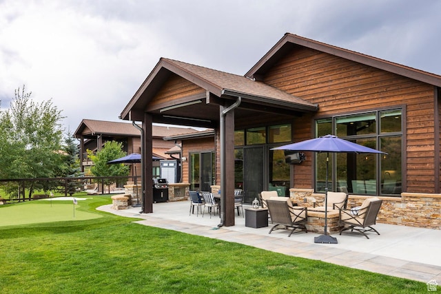 back of house with a fire pit, a yard, and a patio