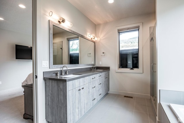 full bathroom featuring connected bathroom, baseboards, a sink, and double vanity