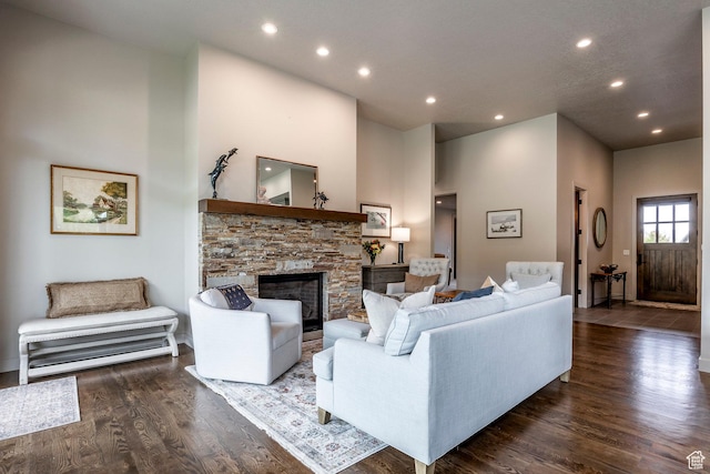 living room featuring a fireplace, a high ceiling, wood finished floors, and recessed lighting