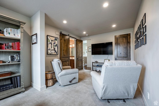 carpeted living area featuring a barn door, baseboards, and recessed lighting