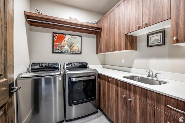 clothes washing area featuring washer and clothes dryer, light tile patterned flooring, a sink, and cabinet space
