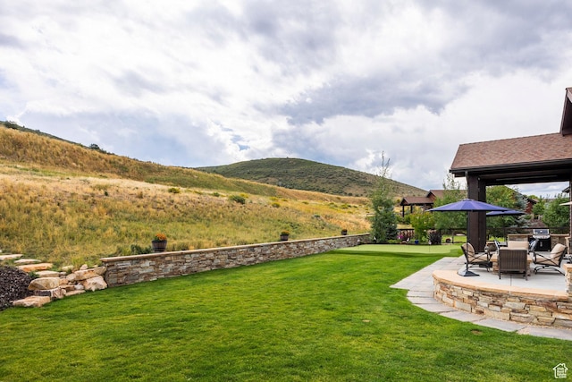 view of yard featuring a mountain view and a patio