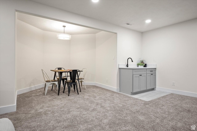 dining room with baseboards, recessed lighting, wet bar, and light carpet