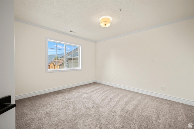 carpeted spare room with a textured ceiling, baseboards, ornamental molding, and visible vents
