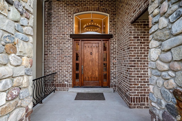 view of exterior entry featuring brick siding