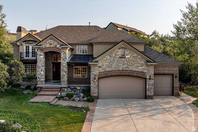 french country inspired facade featuring stone siding, a balcony, concrete driveway, and a garage