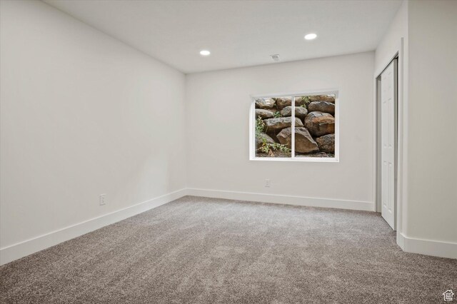 carpeted spare room featuring baseboards and recessed lighting
