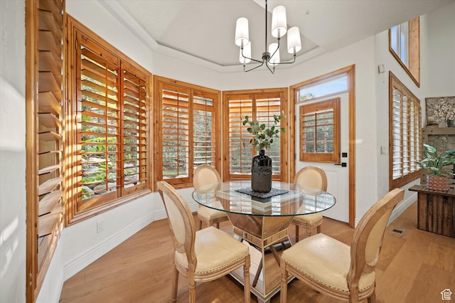 dining room with baseboards, ornamental molding, light wood-style flooring, and a chandelier
