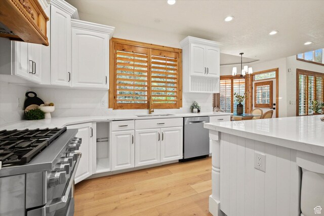 kitchen with light countertops, a sink, stainless steel appliances, and a chandelier