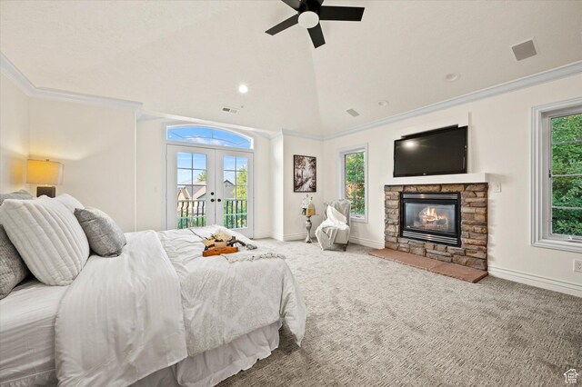 carpeted bedroom featuring a stone fireplace, crown molding, french doors, and access to outside