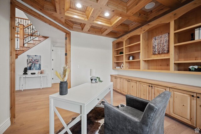home office with light wood-style flooring, coffered ceiling, and beamed ceiling