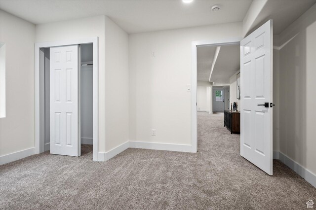 unfurnished bedroom with baseboards, a closet, and carpet floors