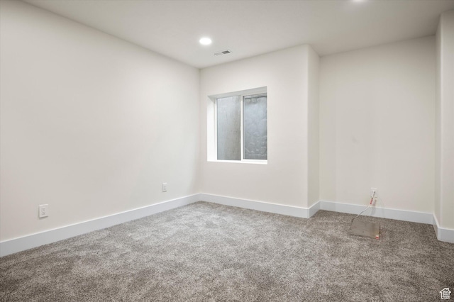 carpeted empty room with baseboards, visible vents, and recessed lighting